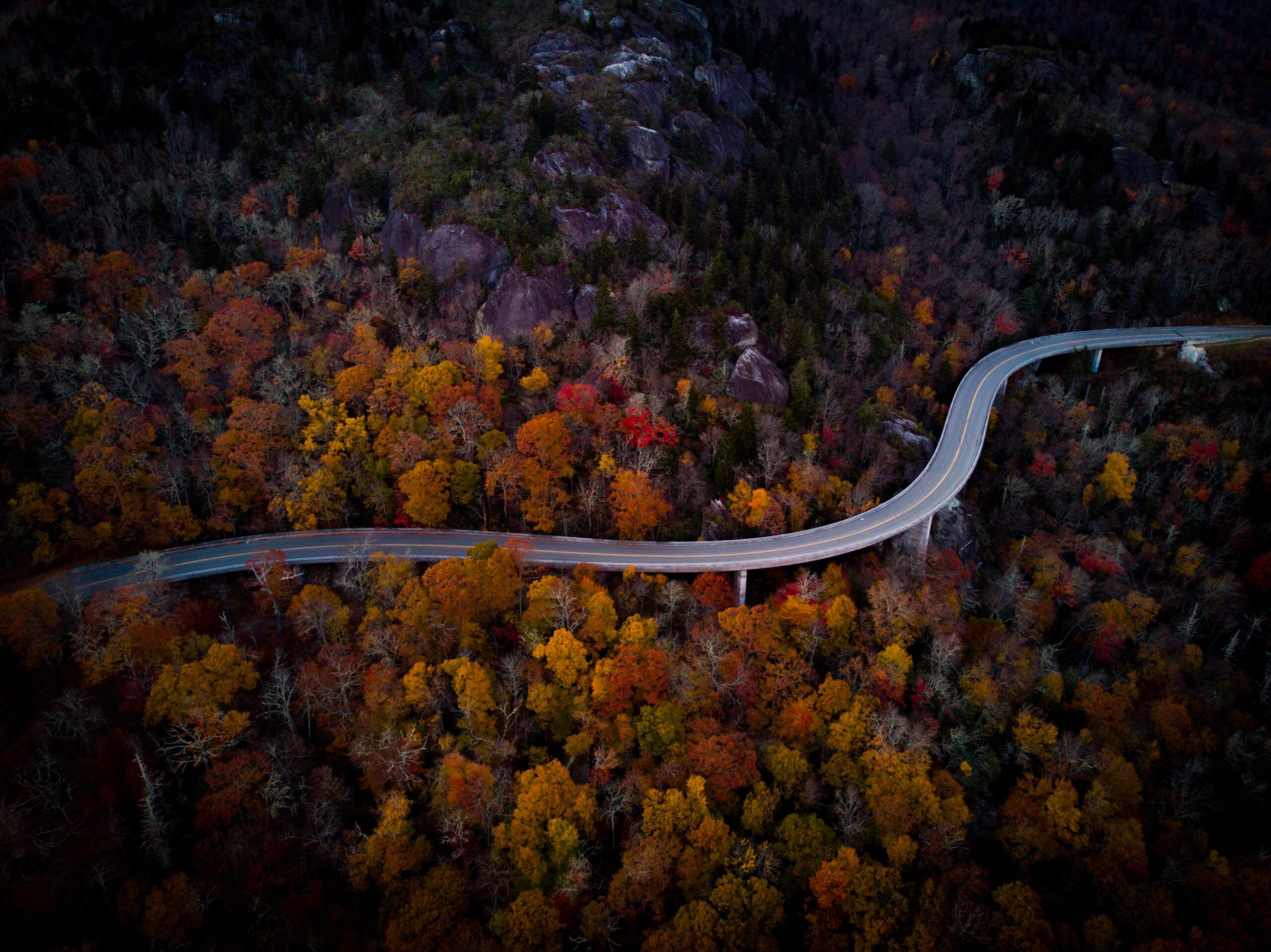 Stunning aerial view of a winding road surrounded by vibrant autumn foliage in Boone, NC.